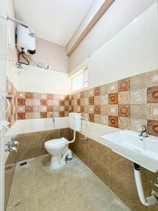 a bathroom with a toilet and a sink at Redfox Service Apartment - Ambattur in Jāmb