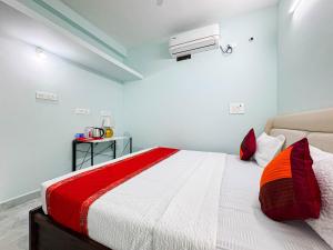 a bedroom with a bed with a red and white comforter at Redfox Service Apartment - Ambattur in Jāmb