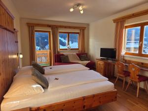 a bedroom with two beds and a desk with a computer at Hotel Restaurant Raunig in Bad Kleinkirchheim