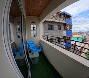 a balcony with two chairs and a view of a building at Akany Tsitoha in Tanjombato
