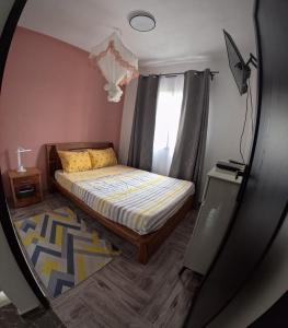 a small bedroom with a bed in a mirror at Akany Tsitoha in Tanjombato
