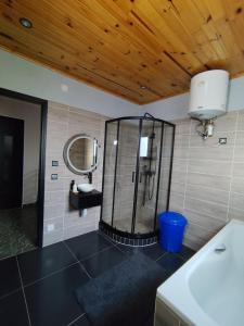 a bathroom with a shower with a sink and a mirror at Akany Tsitoha in Tanjombato +10 photos