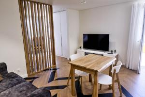 a living room with a wooden table and a television at Mid-Atlantic House in Angra do Heroísmo