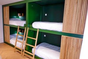 a room with three bunk beds in a green room at Mid-Atlantic House in Angra do Heroísmo