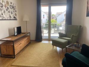 a living room with a tv and a couch and a chair at Art Apart Stuttgart in Rutesheim +9 photos