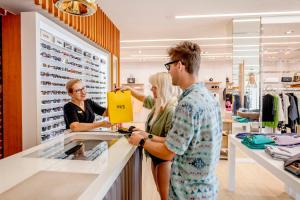 three people standing at a counter in a clothing store at Anfi del Mar in La Playa de Arguineguín +122 photos