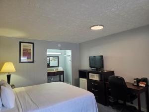 a hotel room with a bed and a desk and a television at Travelowes Motel - Maggie Valley in Maggie Valley