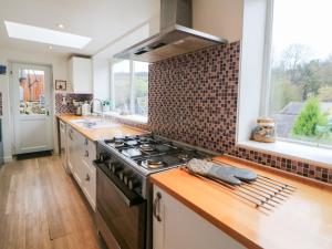 a kitchen with a stove top oven next to a window at Roseville in Matlock