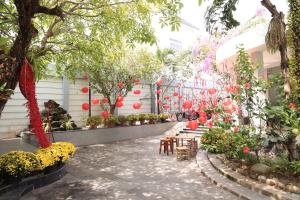 a garden with red lanterns and tables and trees at Hugo Hotel in Phú Quốc