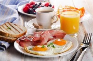 a table with two plates of eggs and toast and a cup of coffee at Hotel SP Grand Near Mohali Bus Stand & Civil Hospital in Mohali
