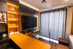 a hotel room with a table and a television at Flat Exclusivo Studio Cuiabá 1604 in Cuiabá