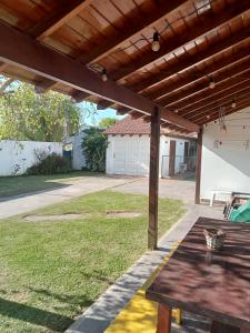 an outdoor patio with a wooden pergola at Chalet con pileta in Miramar
