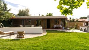 a backyard of a house with a patio and grass at Casa Mocha by RentalsPro - Vourvourou Halkidiki in Vourvourou