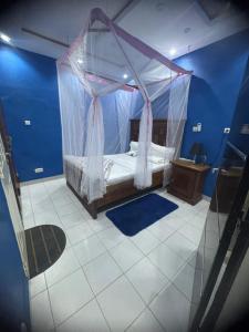 a bedroom with a canopy bed in a blue room at STUDIO A Mbour in Mbour