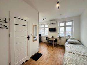 a bedroom with a bed and a desk in a room at Apartamenty przy Galerii in Kluczbork