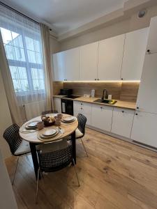 a kitchen with a table and chairs in a room at Old Town Rynek Apartament in Grudziądz