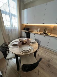 a kitchen with a wooden table and chairs and a table and chairsktop at Old Town Rynek Apartament in Grudziądz
