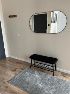 a room with a mirror and a bench and a rug at Old Town Rynek Apartament in Grudziądz