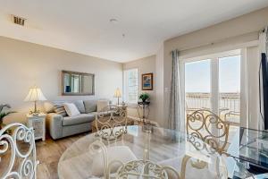 a living room with a couch and a glass table at Grand Caribbean 104 in Orange Beach