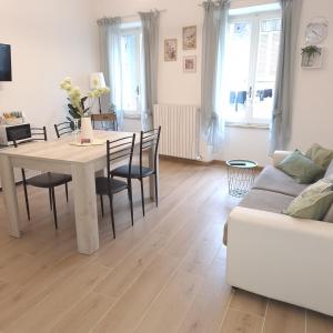 a living room with a table and chairs and a couch at Elunà Assisi Home in Assisi