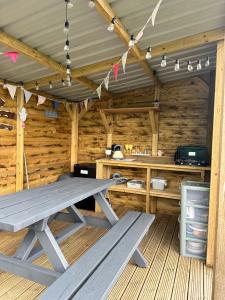 a wooden cabin with a picnic table in it at Gypsy bow top caravan in Llangrannog