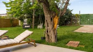 a hammock in a yard next to a tree at Casa Mocha by RentalsPro - Vourvourou Halkidiki in Vourvourou