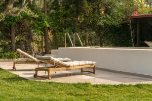 a couple of benches sitting next to a pool at Casa Mocha by RentalsPro - Vourvourou Halkidiki in Vourvourou