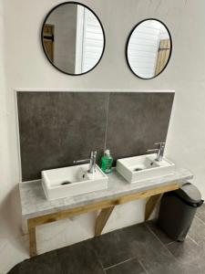 a bathroom with two sinks and two mirrors at Gypsy bow top caravan in Llangrannog +40 photos