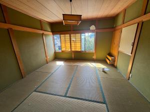 an empty room with a room with a ceiling and a window at ゲストハウス虎のいえ in Sukumo