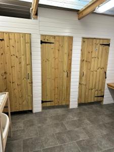 a row of wooden doors in a garage at Gypsy bow top caravan in Llangrannog