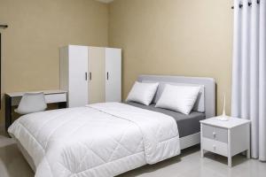 a bedroom with a white bed and a white cabinet at Milestone City Business Apartment - Secure Area - Fast WiFi Long Stay in Antananarivo +89 photos