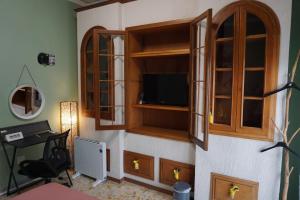 a room with a tv and a desk in a room at Nice room with private bathroom in Ercolano