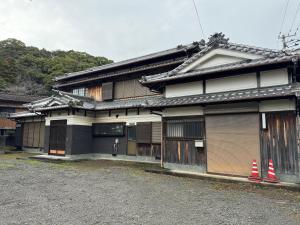 an old building with two orange cones in front of it at ゲストハウス虎のいえ in Sukumo