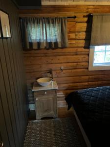 a bathroom with a sink in a log cabin at Chalet Skogshorn in Markegardlian +69 photos