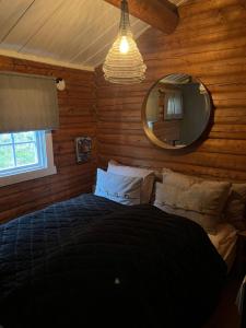 a bedroom with a large bed with a mirror at Chalet Skogshorn in Markegardlian