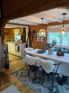 a kitchen and dining room with a table and chairs at Chalet Skogshorn in Markegardlian