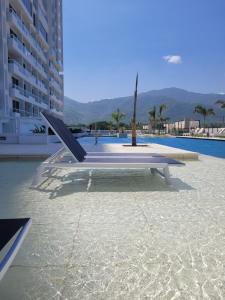 a bench sitting next to a swimming pool at Porto Horizonte suite 424 in Playa Bello Horizonte