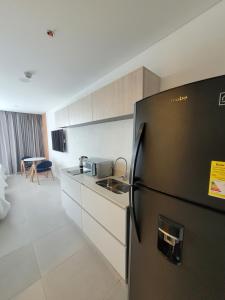 a kitchen with a black refrigerator in a room at Porto Horizonte suite 424 in Playa Bello Horizonte
