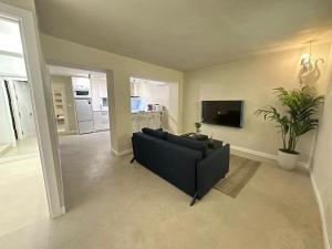 a living room with a black couch and a tv at Sol Mediterráneo - Palm City 2 in Elche