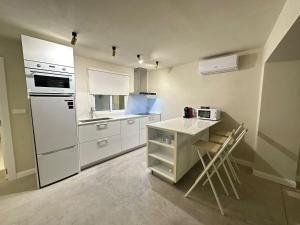 a kitchen with white appliances and a table and chairs at Sol Mediterráneo - Palm City 2 in Elche