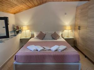 a bedroom with a bed with two pillows and two lamps at SUNNY STUDIO in Skala Marion