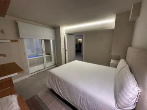 a bedroom with a white bed and a large window at Sol Mediterráneo - Palm City 2 in Elche +12 photos