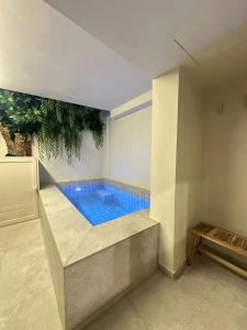 a swimming pool in a room with a blue floor at Sol Mediterráneo - Palm City 2 in Elche