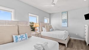 a white bedroom with two beds and a window at Salty Seabreeze in Seacrest +70 photos