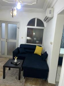 a living room with a blue couch and a table at Eilena prestige in Douala