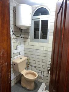 a small bathroom with a toilet and a window at Eilena prestige in Douala