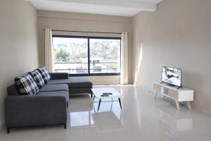 a living room with a couch and a tv at Milestone City Business Apartment - Secure Area - Fast WiFi Long Stay in Antananarivo
