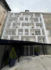 a building with two potted trees in front of it at Alexandar Square Suites in Skopje