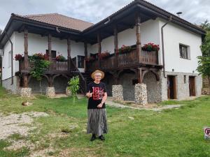 a woman standing in front of a house at The Carpathian Lodge in Runcu