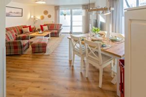 a kitchen and living room with a table and chairs at Küstenkoje in Neßmersiel